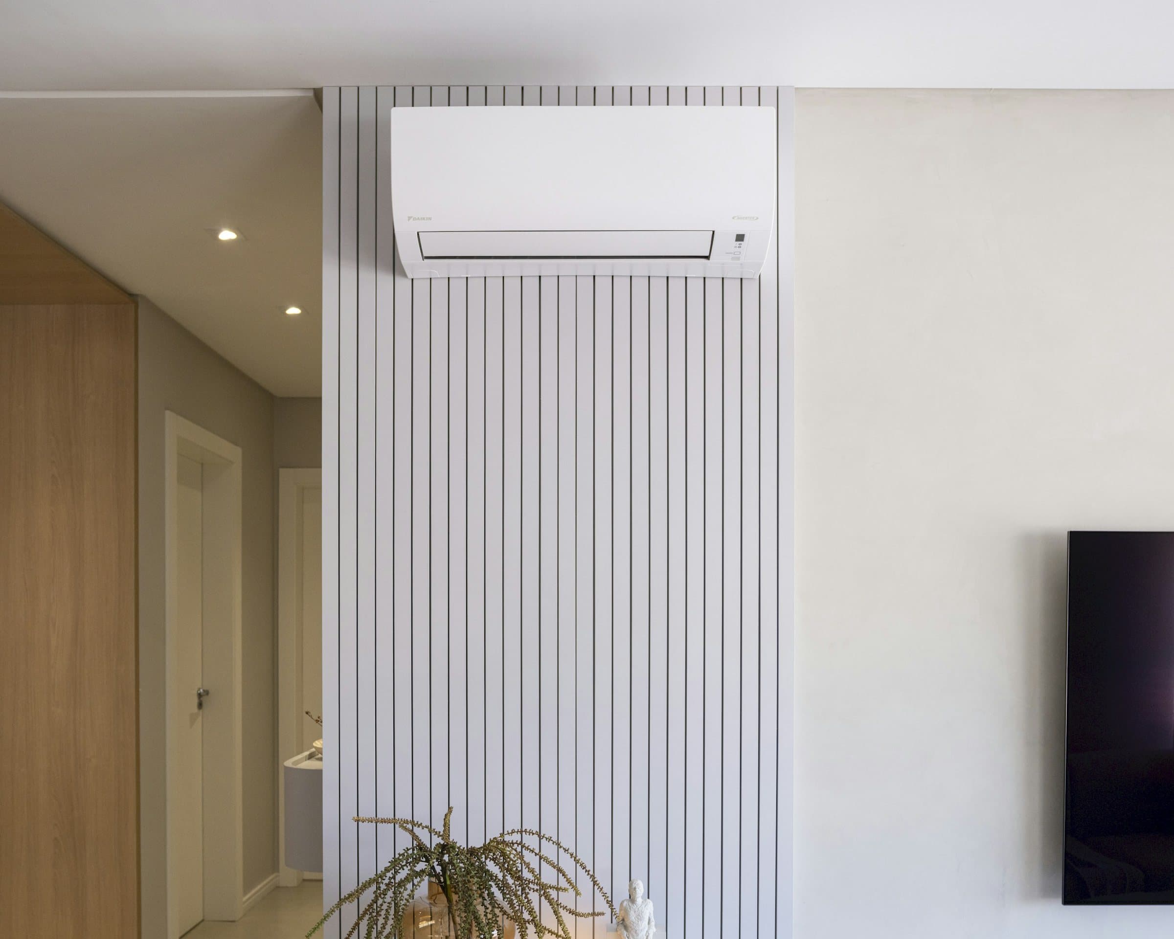 Wall-mounted split system neatly installed on a panelled feature wall in a modern home